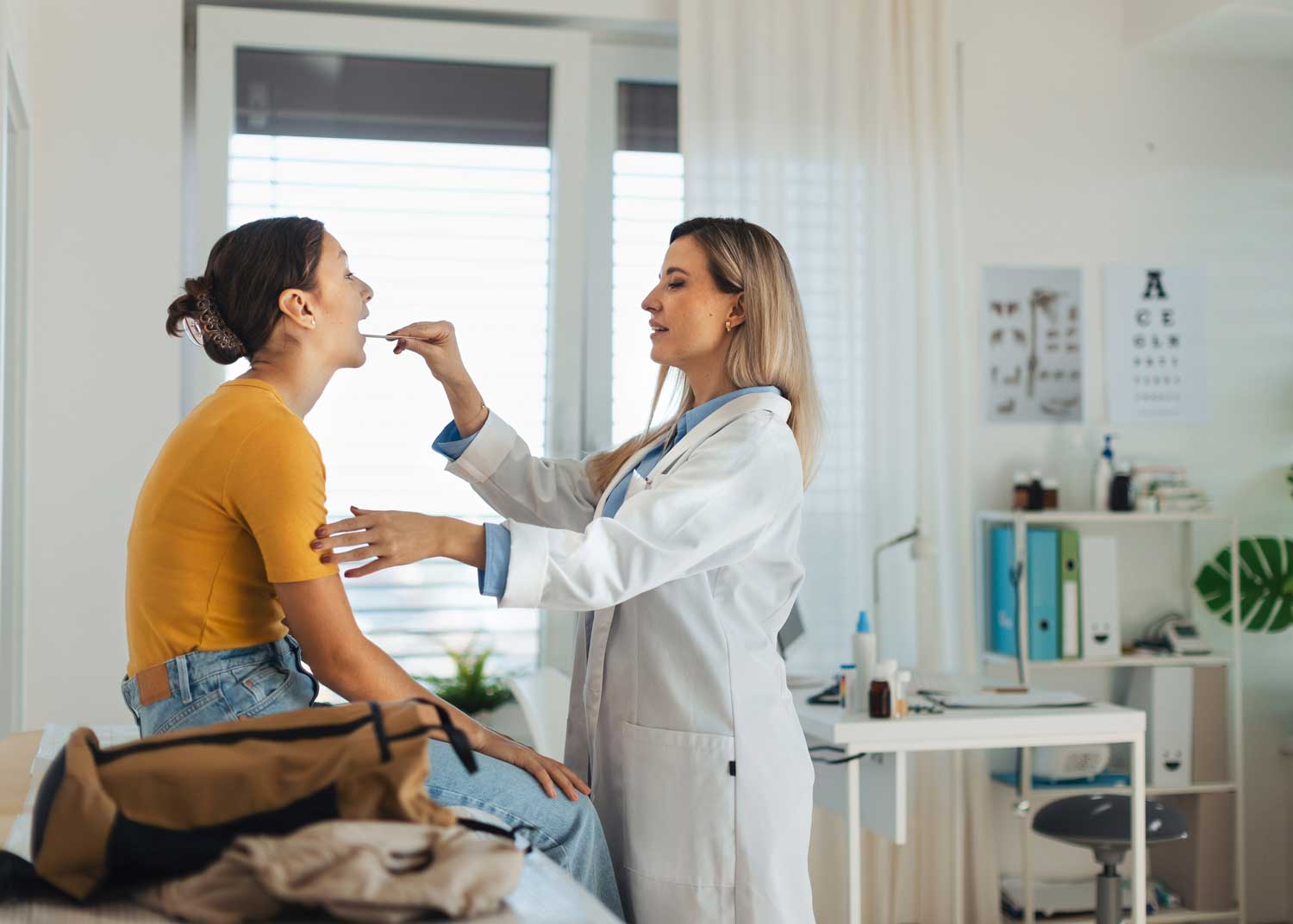 A young woman gets a throat exam in a doctor's office